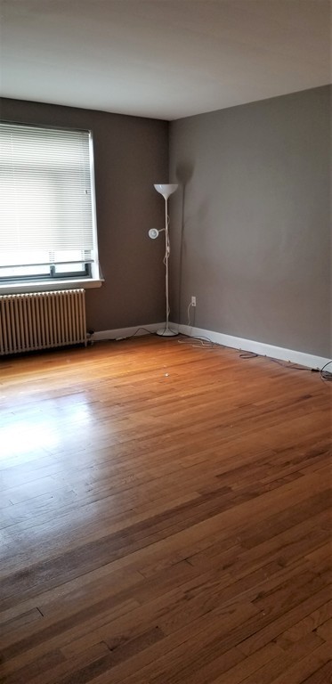 14 Ashland Street, Unit 2R Worcester, MA 01609 - Photo 3 of 16 a view of an empty room with wooden floor and a window