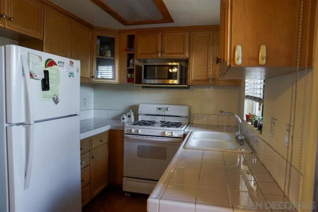a kitchen with stainless steel appliances granite countertop a refrigerator sink and stove