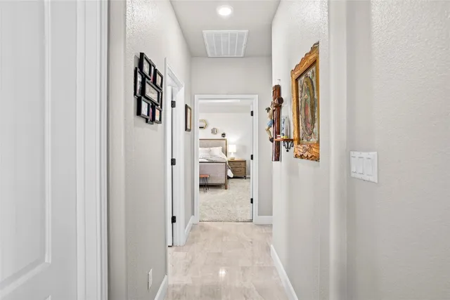 a view of a hallway with bathroom and shower