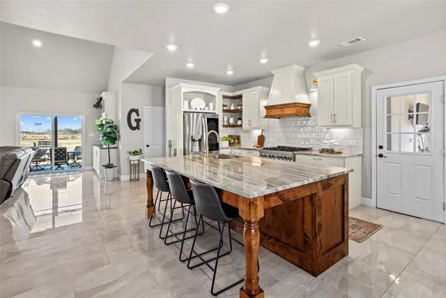 a kitchen with granite countertop kitchen island stainless steel appliances a sink and counter space