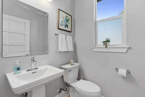 a bathroom with a sink mirror and toilet