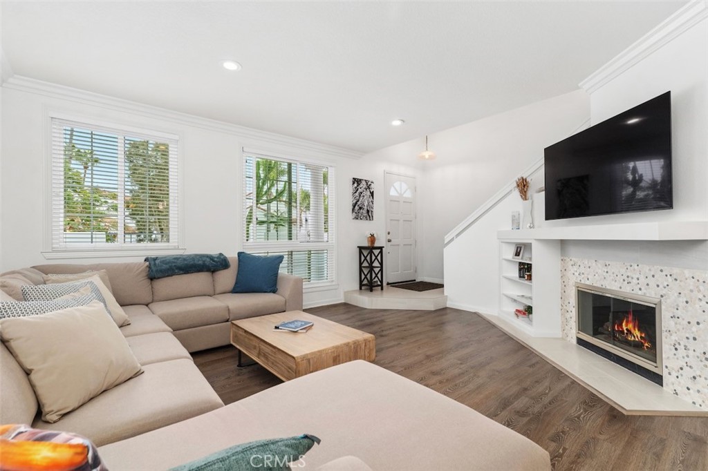 19451 Pompano Lane, Unit 110 Huntington Beach, CA 92648 - Photo 1 of 54 a living room with furniture a flat screen tv and a fireplace
