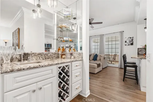 a living room with stainless steel appliances furniture and a kitchen view