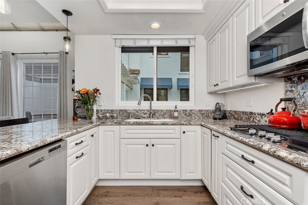 19451 Pompano Lane, Unit 110 Huntington Beach, CA 92648 - Photo 15 of 54 a kitchen with granite countertop a sink stove and cabinets