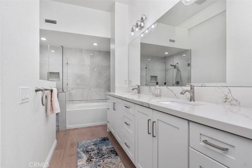 19451 Pompano Lane, Unit 110 Huntington Beach, CA 92648 - Photo 25 of 54 a bathroom with a double vanity sink mirror double and a bathtub