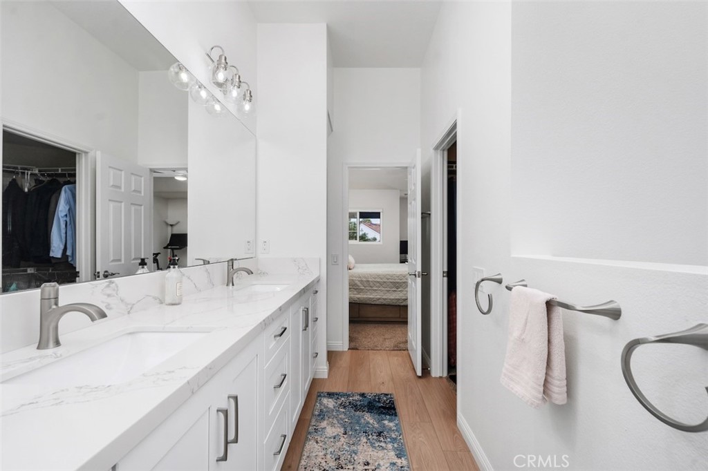 19451 Pompano Lane, Unit 110 Huntington Beach, CA 92648 - Photo 28 of 54 a spacious bathroom with a double vanity sink a mirror and shower