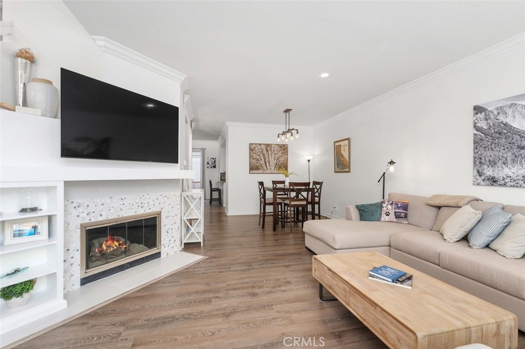 19451 Pompano Lane, Unit 110 Huntington Beach, CA 92648 - Photo 7 of 54 a living room with furniture a fireplace and a flat screen tv