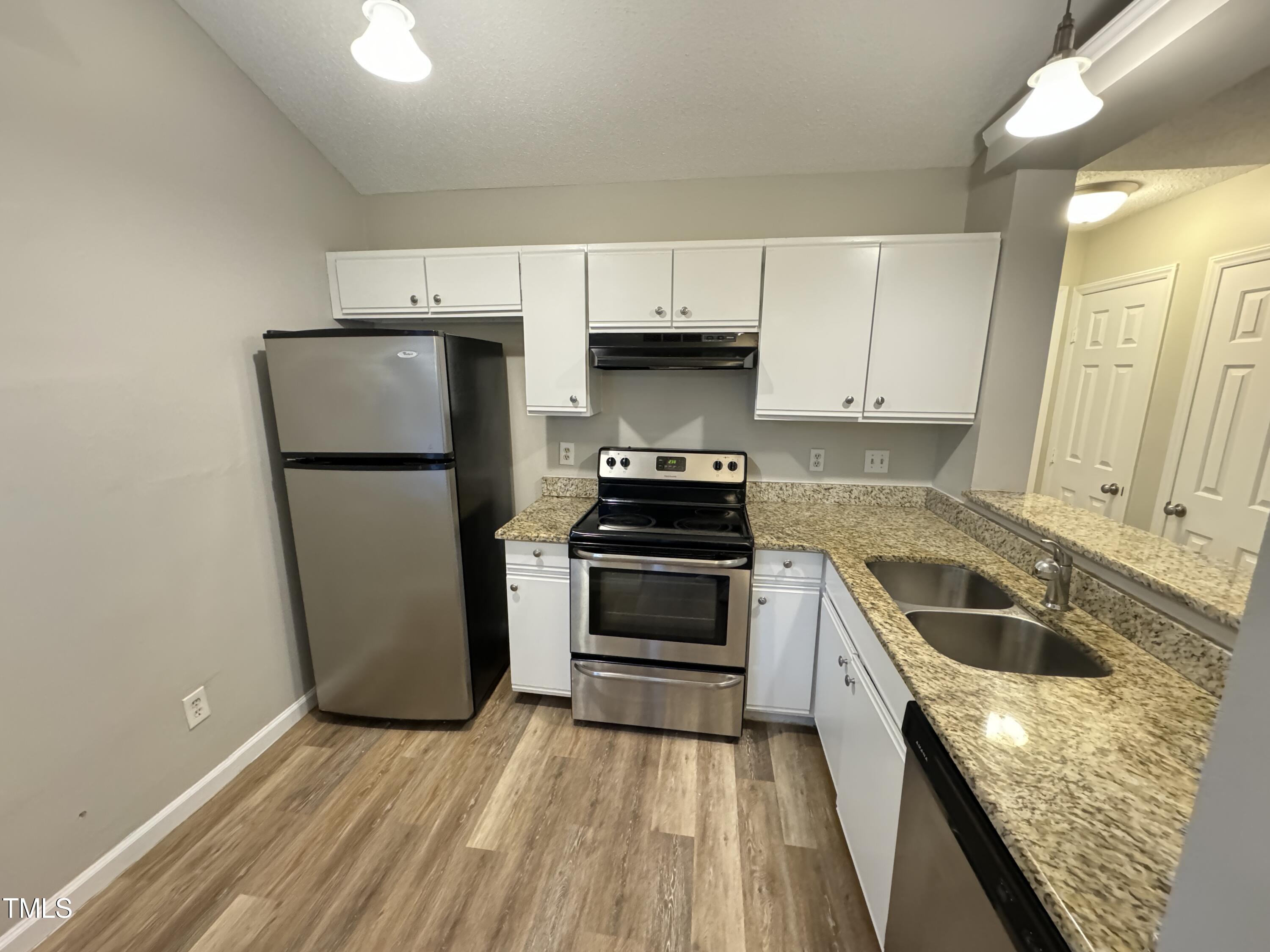 456 Dickens Drive Raleigh, NC 27610 - Photo 13 of 33 a kitchen with a sink a refrigerator and cabinets