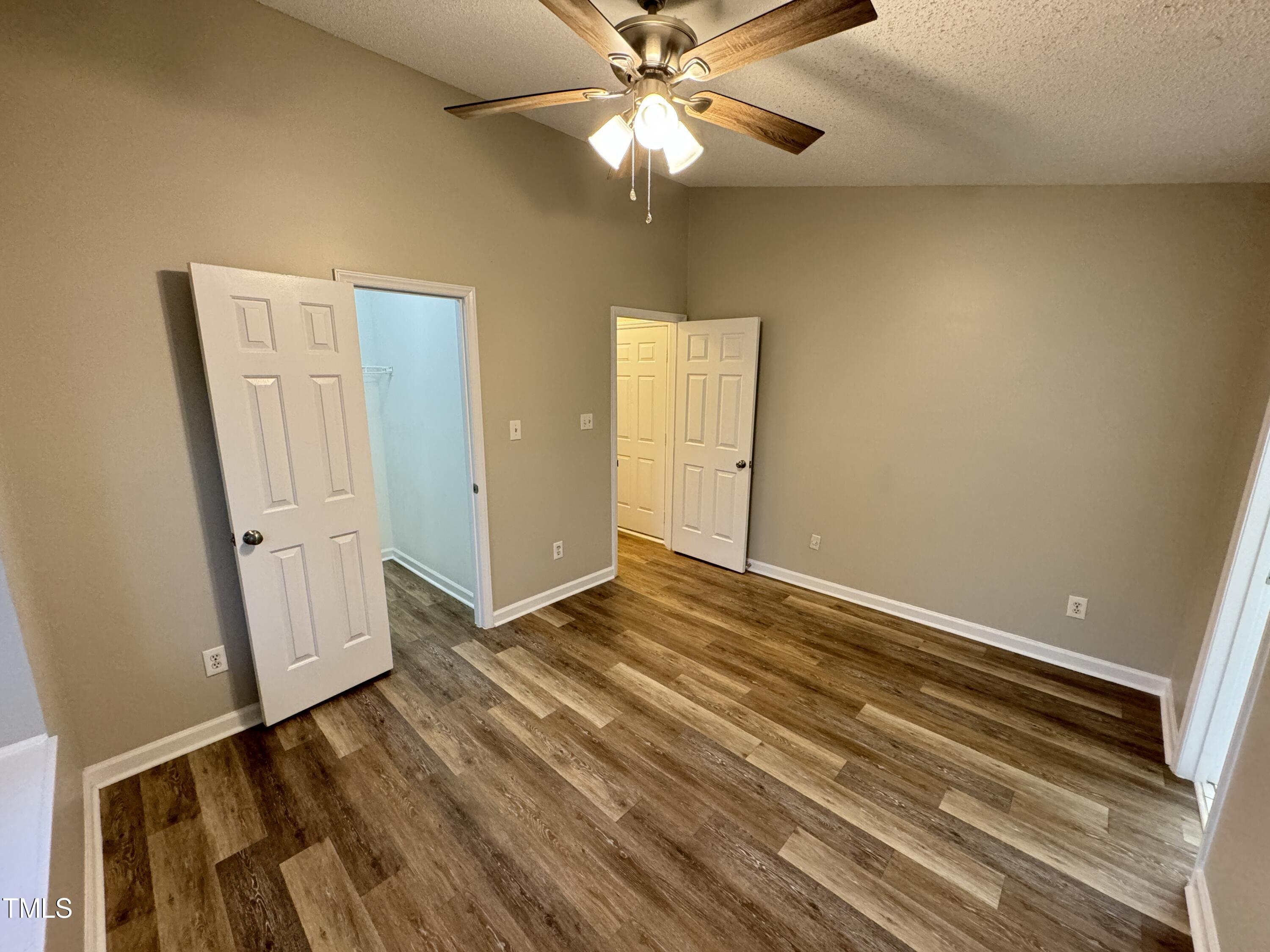 456 Dickens Drive Raleigh, NC 27610 - Photo 17 of 33 a view of an empty room with wooden floor and a ceiling fan