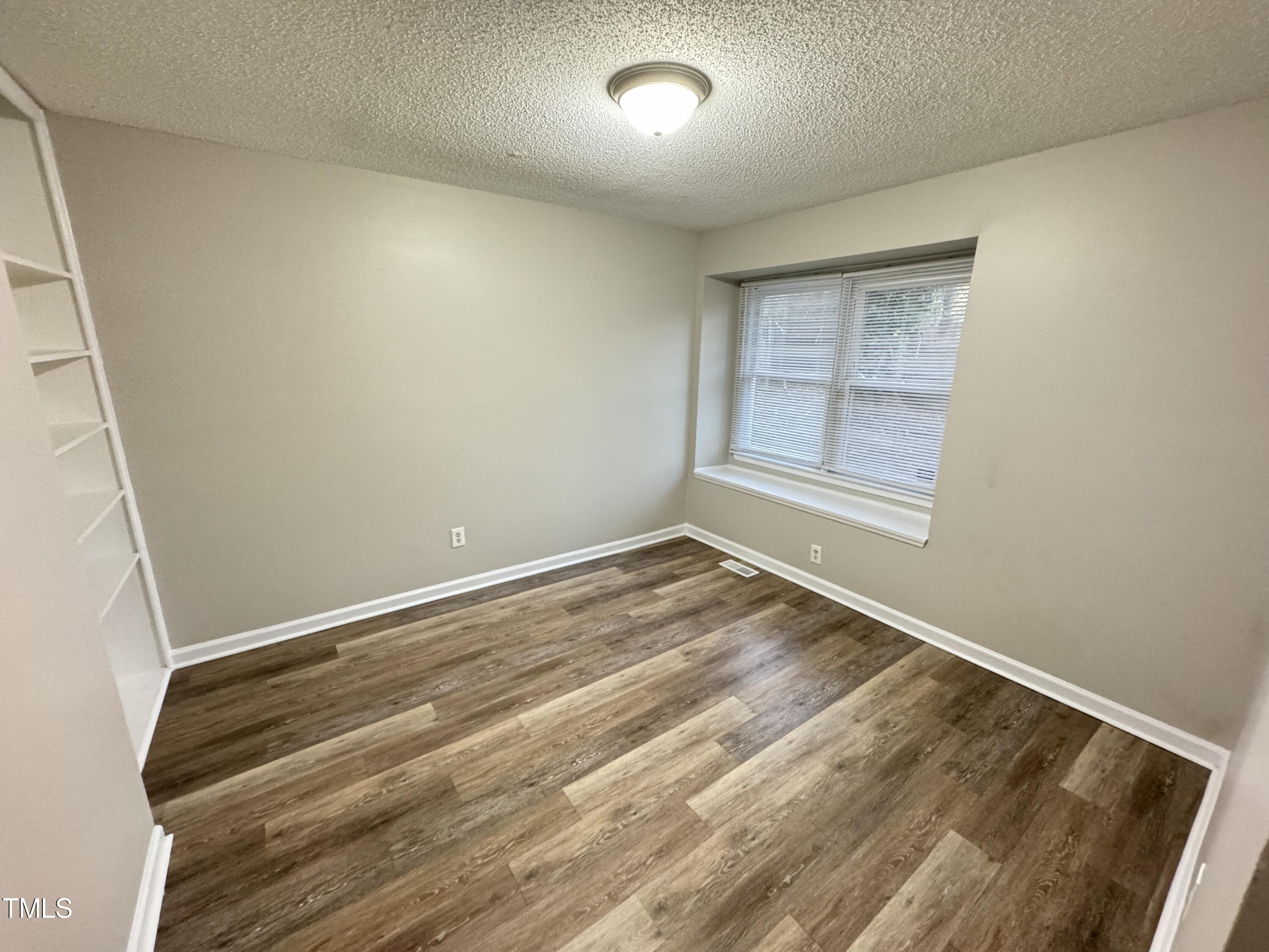 456 Dickens Drive Raleigh, NC 27610 - Photo 23 of 33 an empty room with wooden floor and windows