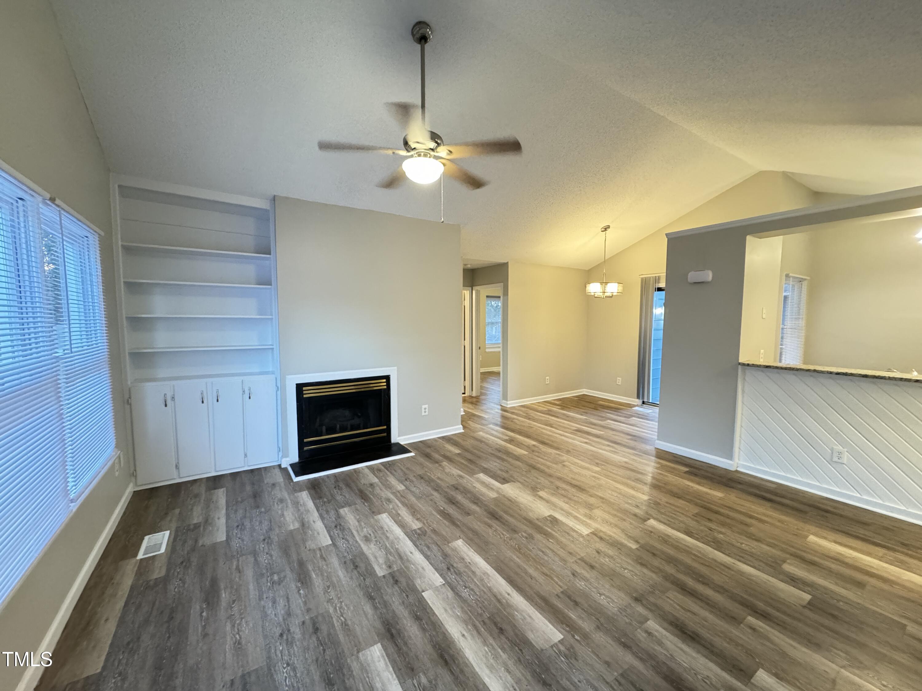 456 Dickens Drive Raleigh, NC 27610 - Photo 8 of 33 a view of empty room with wooden floor and fireplace