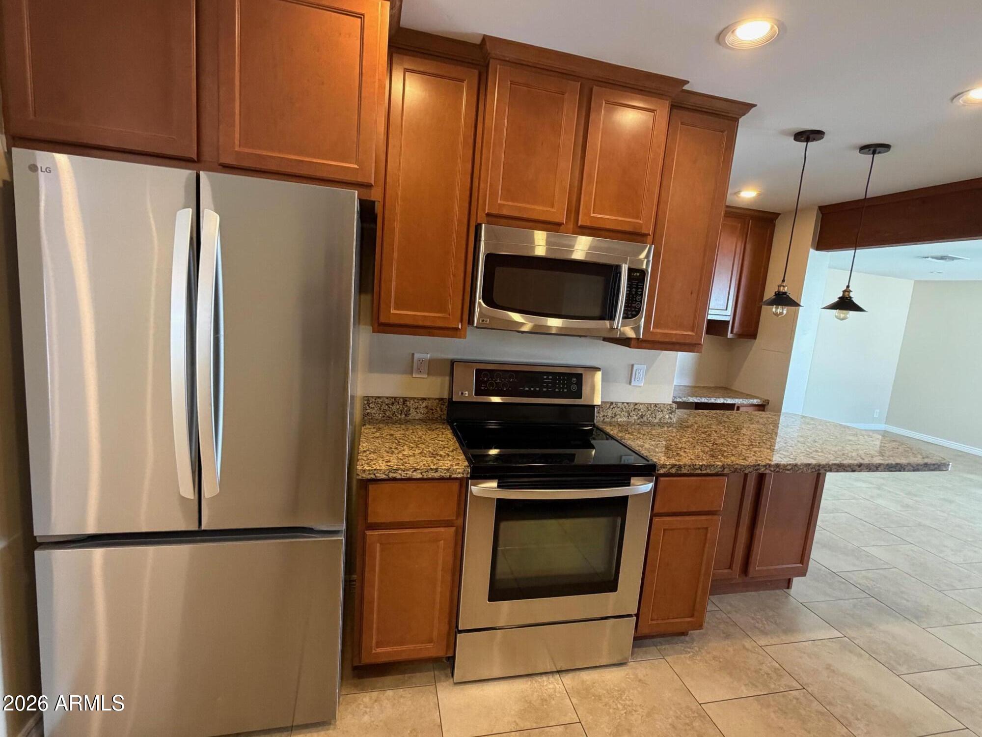 6036 North 8th Street Phoenix, AZ 85014 - Photo 12 of 37 a kitchen with stainless steel appliances a refrigerator stove and microwave