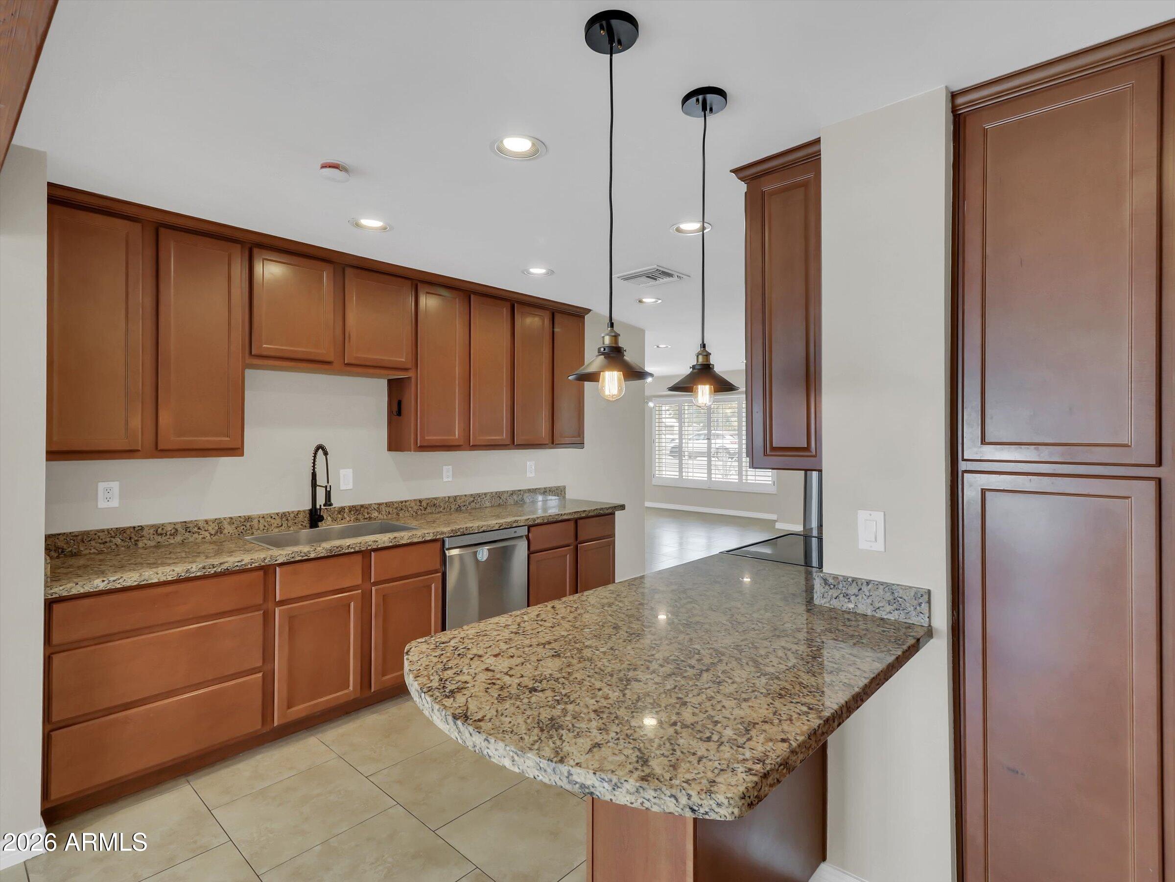 6036 North 8th Street Phoenix, AZ 85014 - Photo 13 of 31 a kitchen with stainless steel appliances granite countertop a sink refrigerator and cabinets