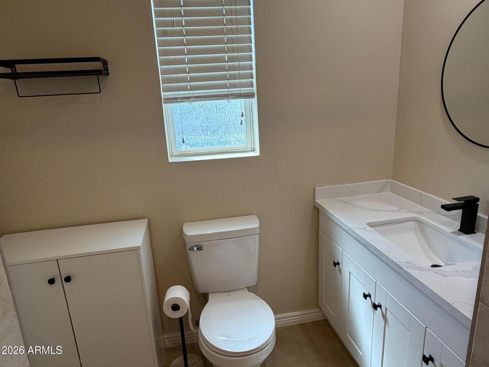 6036 North 8th Street Phoenix, AZ 85014 - Photo 19 of 37 a bathroom with a toilet a sink and a mirror