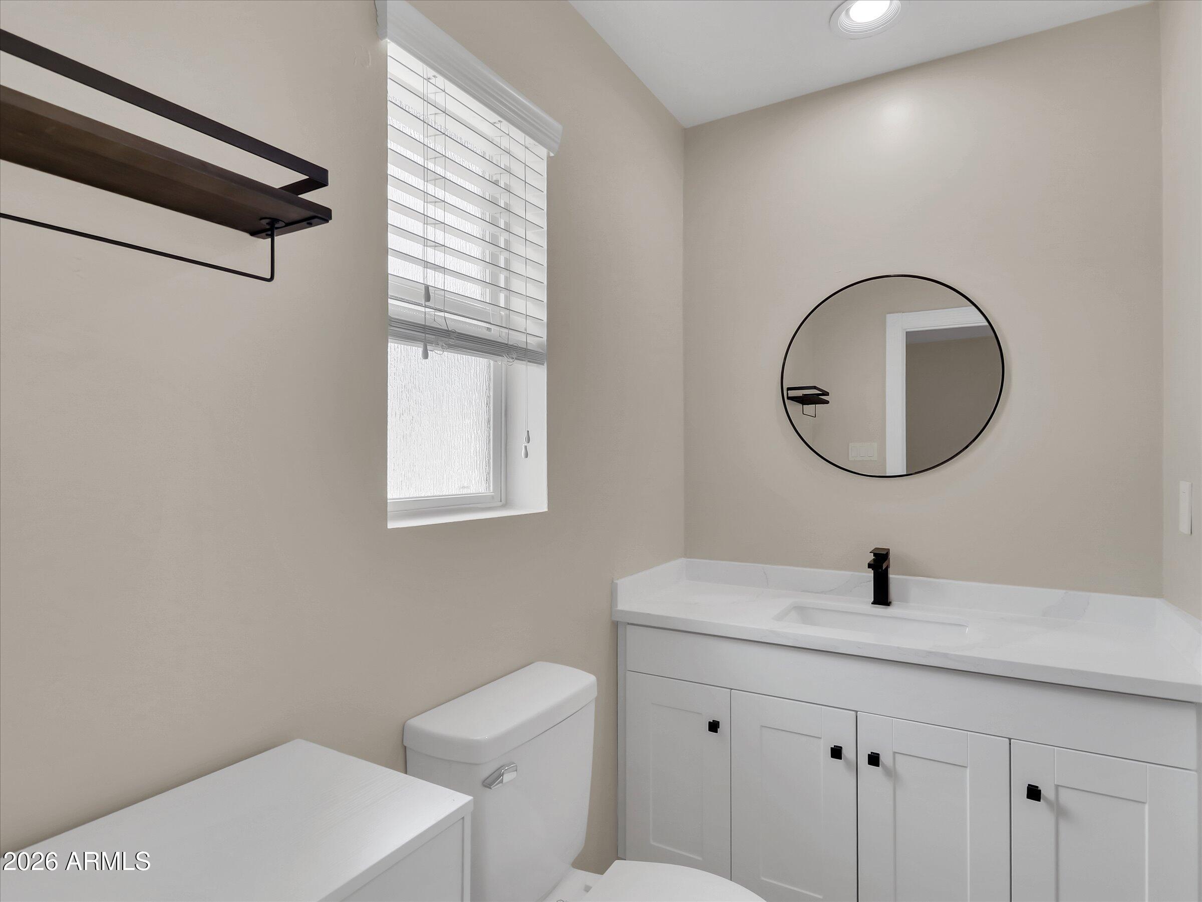 6036 North 8th Street Phoenix, AZ 85014 - Photo 21 of 31 a bathroom with a toilet sink and mirror