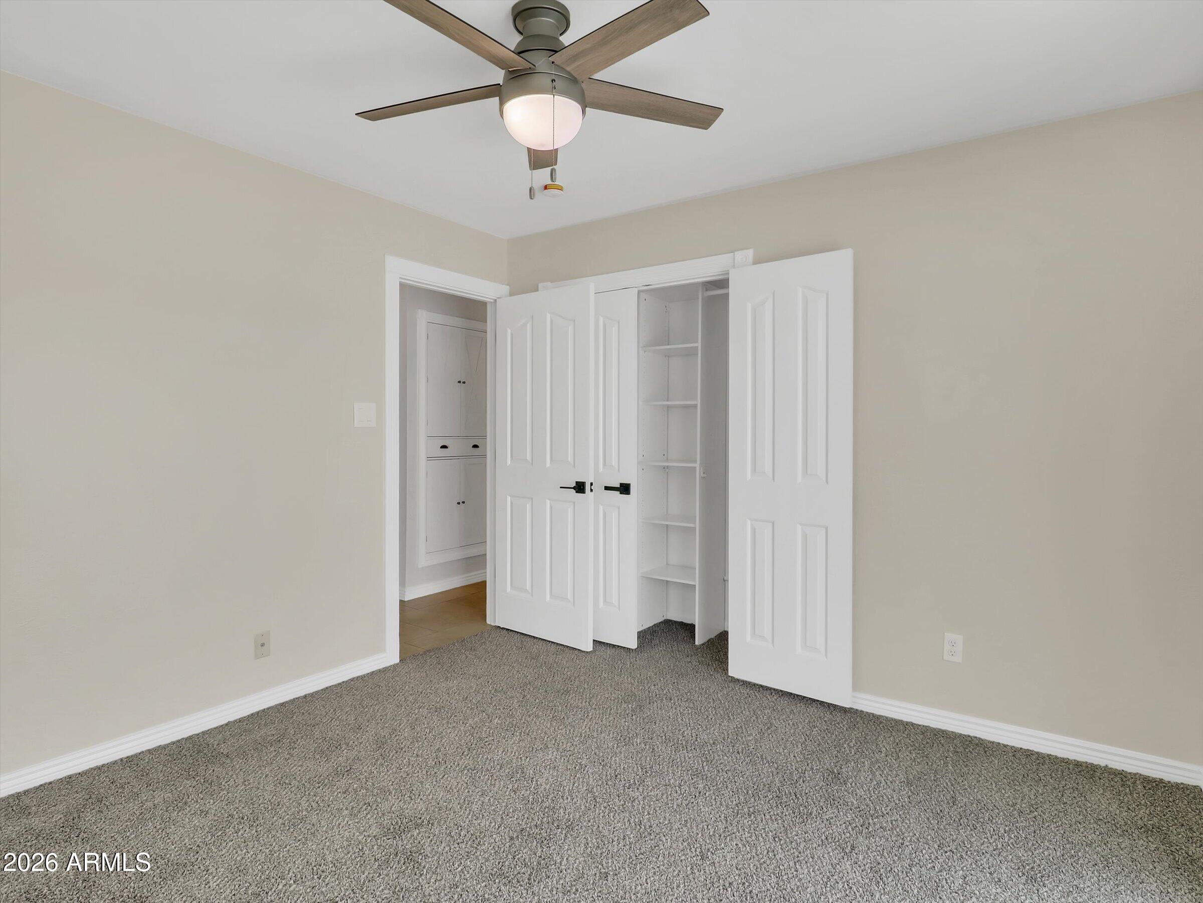 6036 North 8th Street Phoenix, AZ 85014 - Photo 25 of 31 an empty room with a ceiling fan and a window