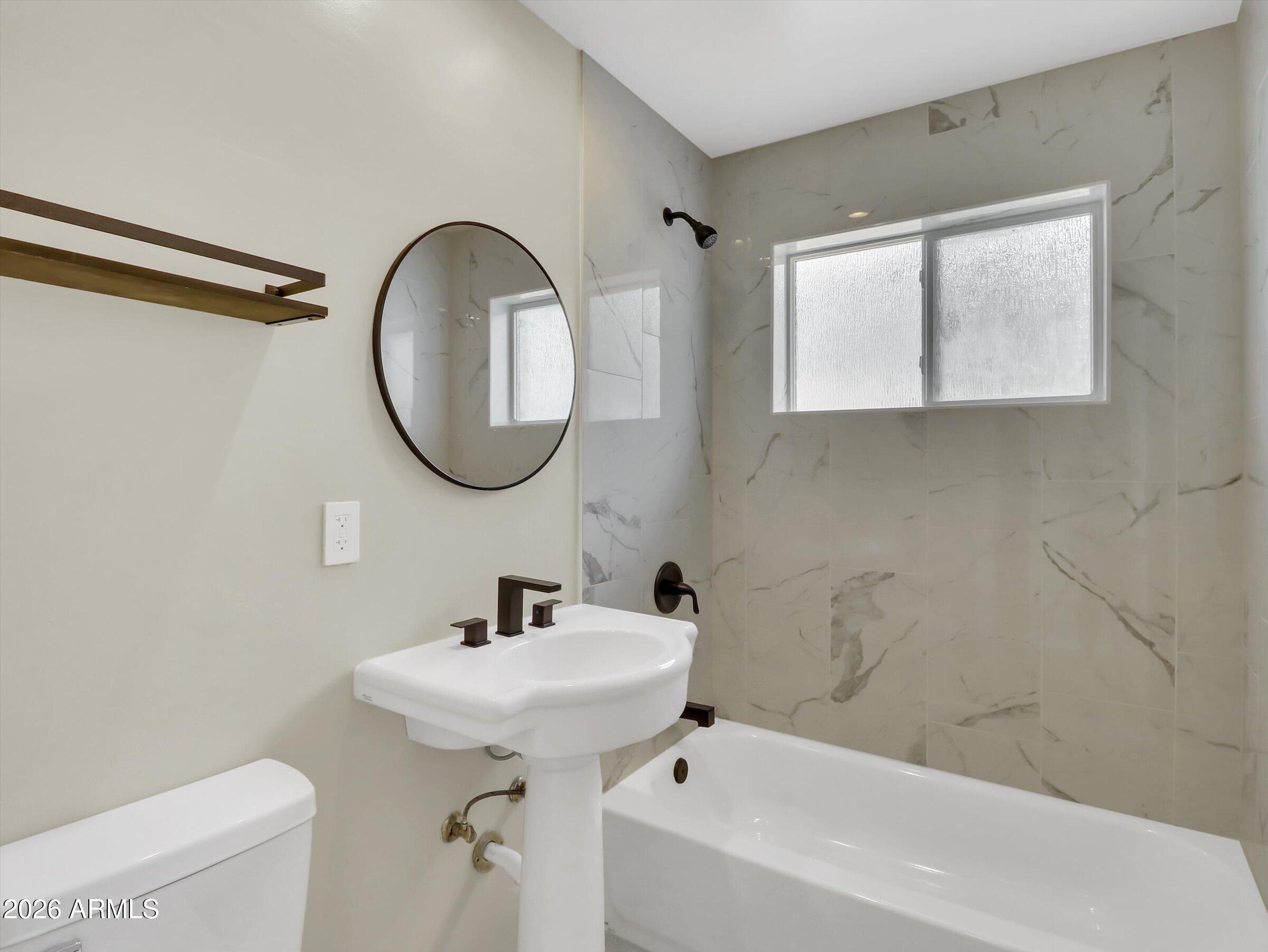6036 North 8th Street Phoenix, AZ 85014 - Photo 26 of 31 a bathroom with a sink a mirror and a toilet