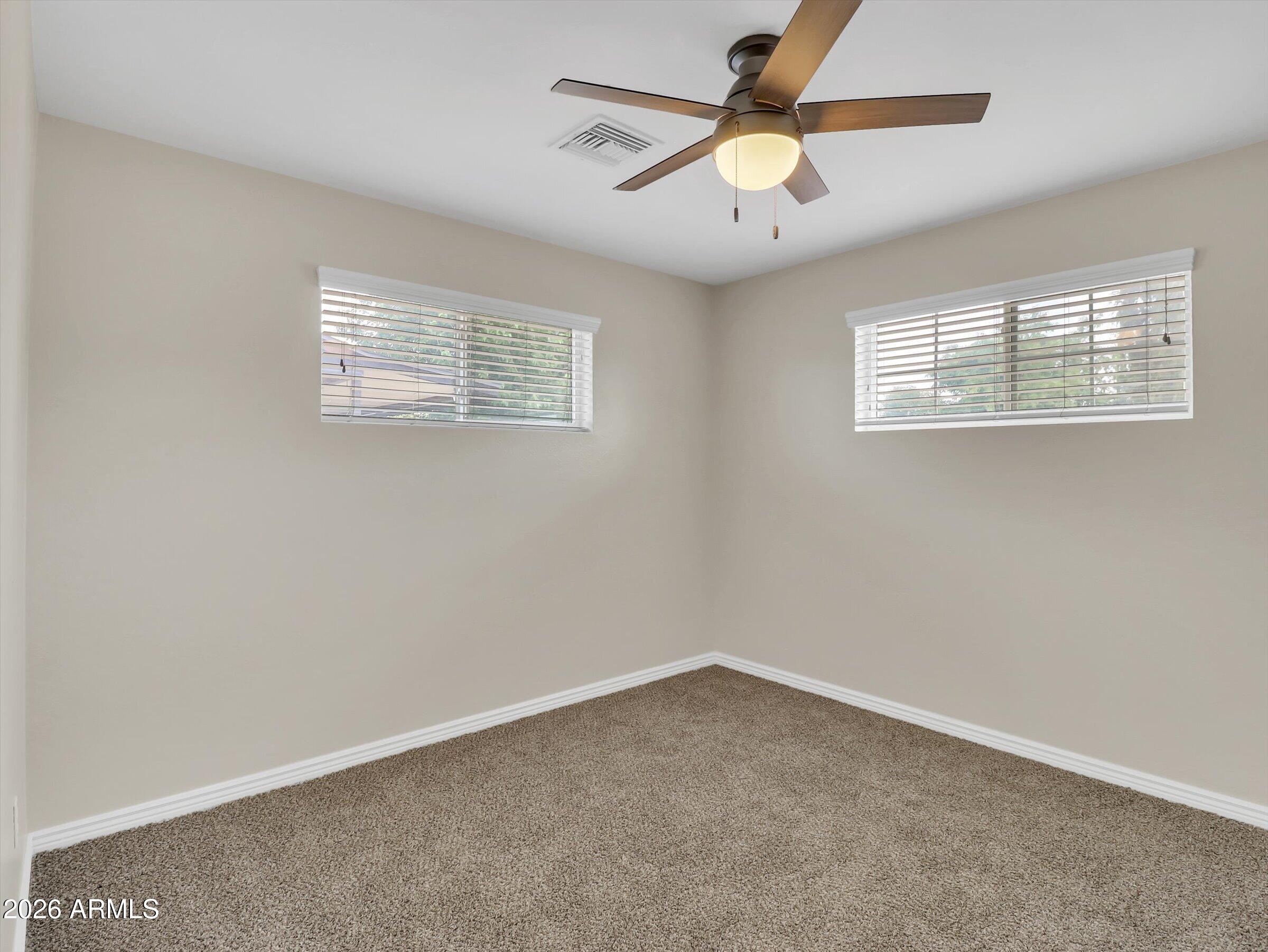 6036 North 8th Street Phoenix, AZ 85014 - Photo 27 of 31 an empty room with a window and a fan