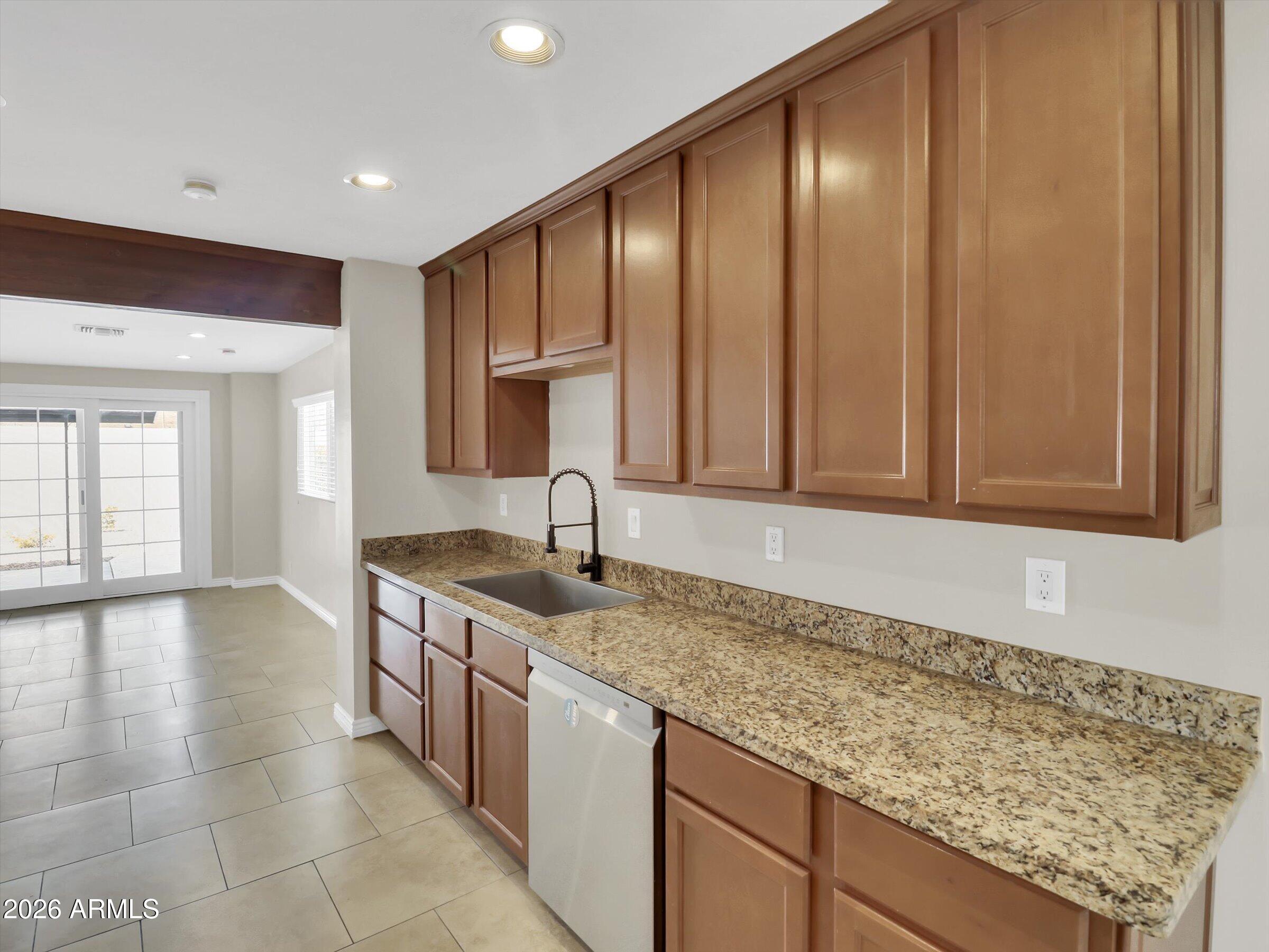 6036 North 8th Street Phoenix, AZ 85014 - Photo 8 of 31 a kitchen with stainless steel appliances granite countertop a sink and a wooden cabinets