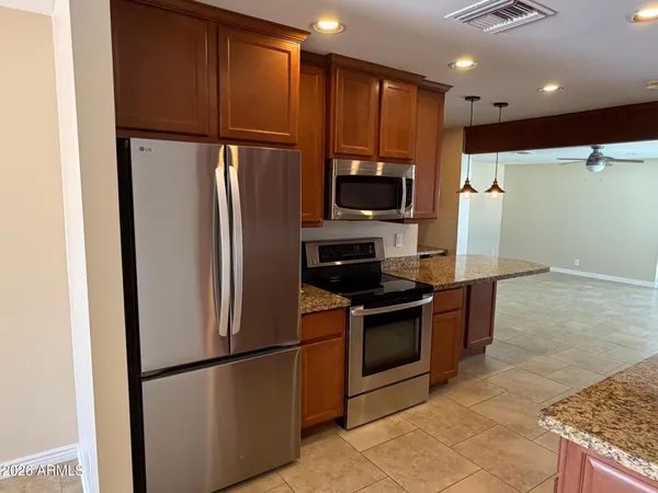 a kitchen with granite countertop a sink stainless steel appliances and cabinets