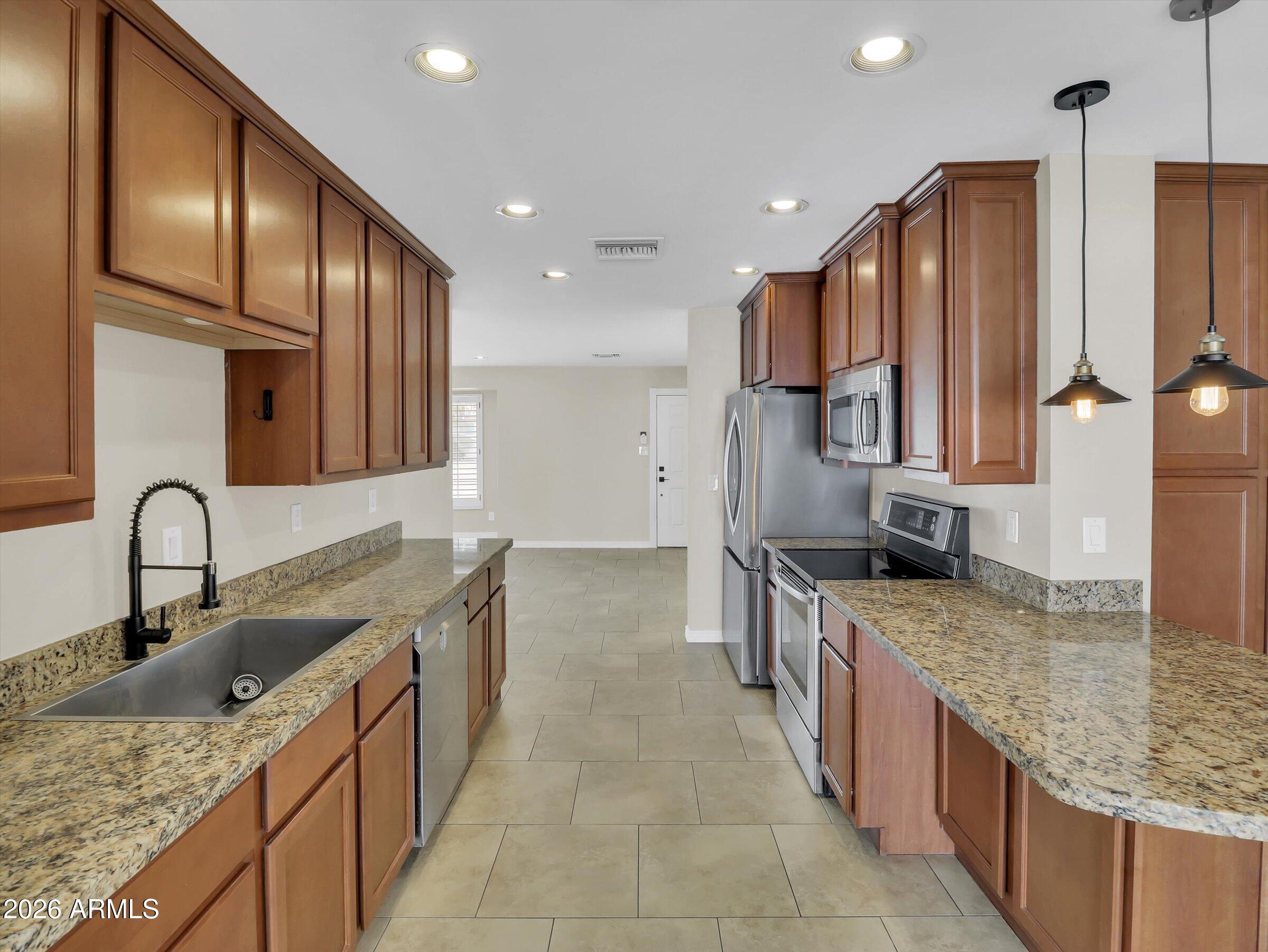 6036 North 8th Street Phoenix, AZ 85014 - Photo 10 of 31 a kitchen with stainless steel appliances granite countertop a sink stove and cabinets