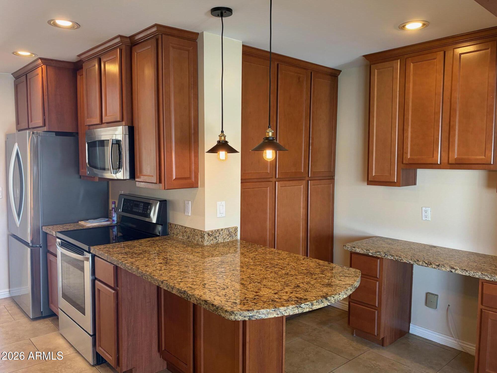 6036 North 8th Street Phoenix, AZ 85014 - Photo 10 of 37 a kitchen with kitchen island granite countertop wooden cabinets a refrigerator and a sink