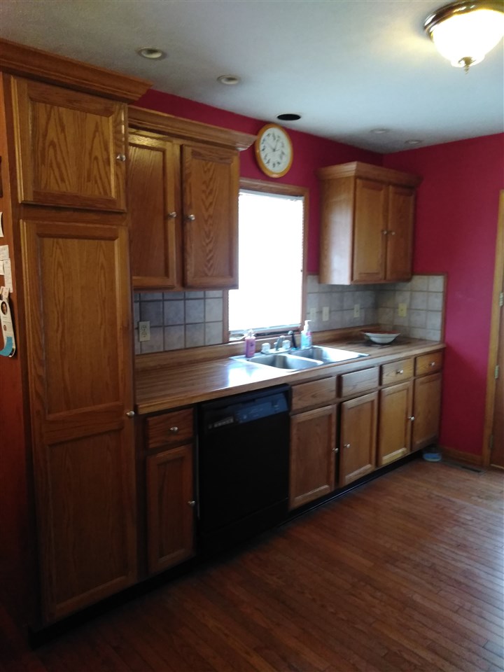1039 South Trainer Road Rockford, IL 61108 - Photo 3 of 18 a kitchen with stainless steel appliances granite countertop a sink a stove cabinets and wooden floor