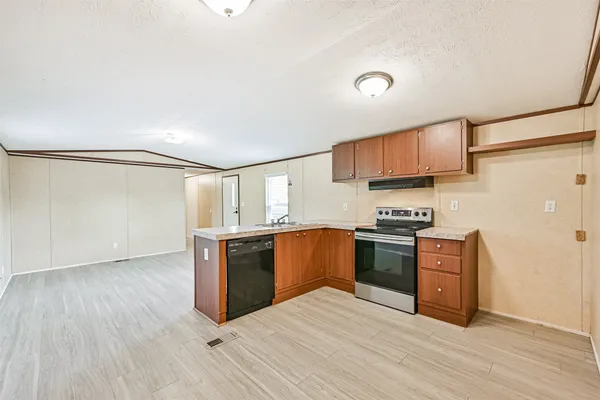 a kitchen with granite countertop cabinets stainless steel appliances and a counter space