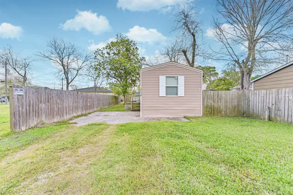 a view of a house with a yard and large tree