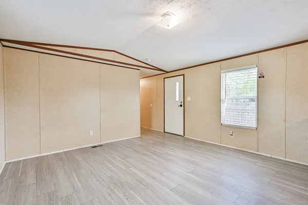 a kitchen with stainless steel appliances granite countertop a refrigerator a sink dishwasher a stove and white countertops with wooden floor