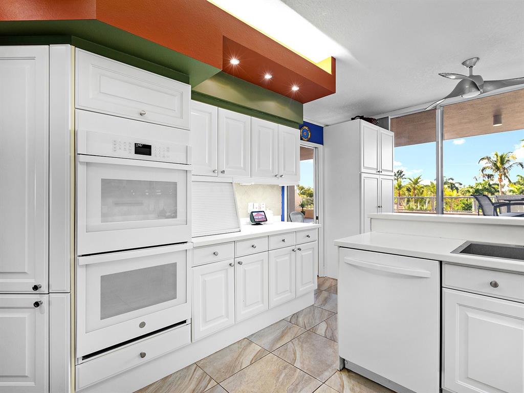 3040 Grand Bay Boulevard, Unit 213 Longboat Key, FL 34228 - Photo 15 of 44 a kitchen with granite countertop white cabinets and white appliances