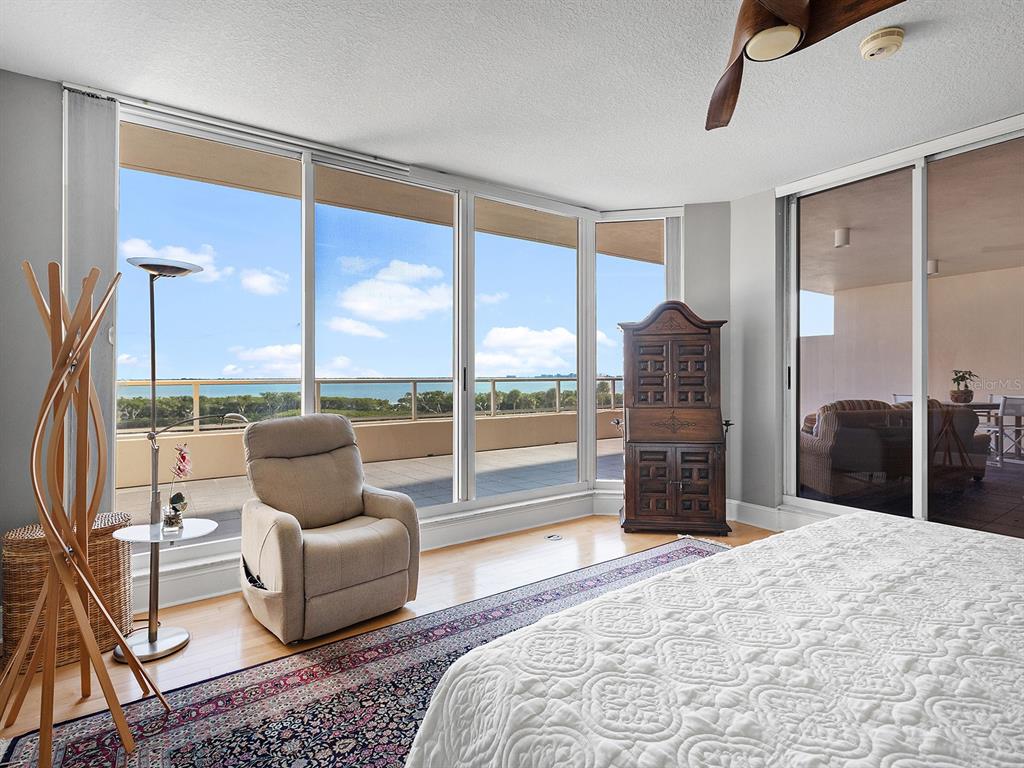 3040 Grand Bay Boulevard, Unit 213 Longboat Key, FL 34228 - Photo 17 of 44 a bedroom with furniture and large windows