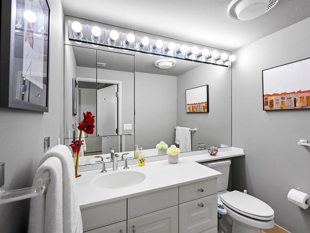 3040 Grand Bay Boulevard, Unit 213 Longboat Key, FL 34228 - Photo 22 of 44 a bathroom with a sink a toilet and shower