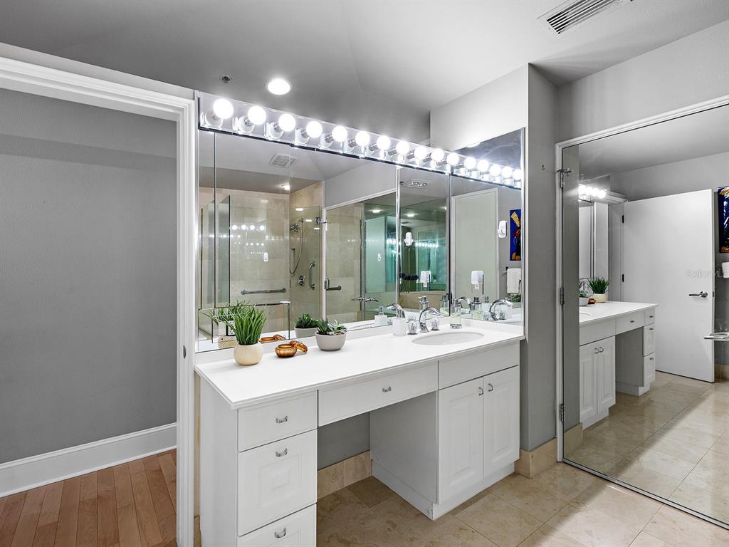 3040 Grand Bay Boulevard, Unit 213 Longboat Key, FL 34228 - Photo 23 of 44 a bathroom with a double vanity sink and mirror with shower
