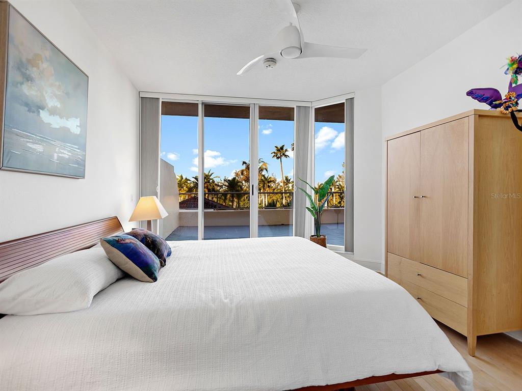 3040 Grand Bay Boulevard, Unit 213 Longboat Key, FL 34228 - Photo 26 of 44 a bedroom with a bed and a chandelier