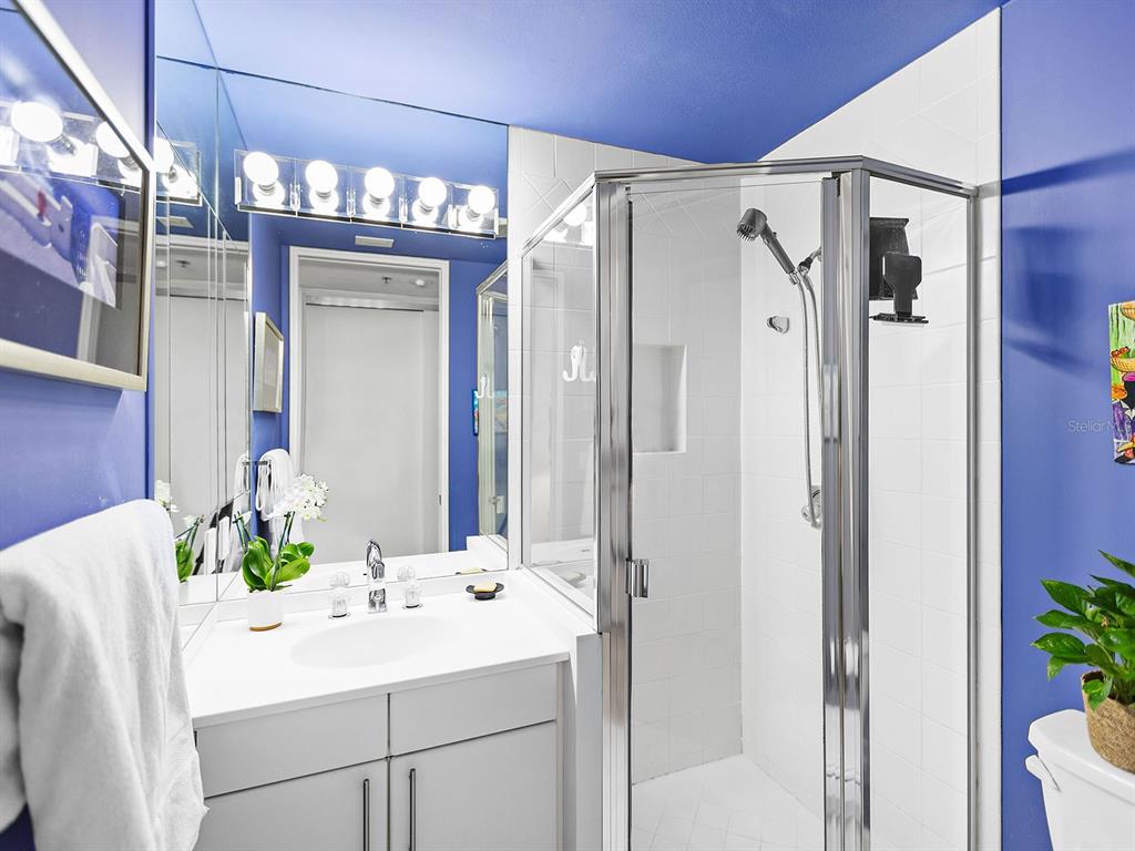 3040 Grand Bay Boulevard, Unit 213 Longboat Key, FL 34228 - Photo 28 of 44 a bathroom with a sink shower and a mirror