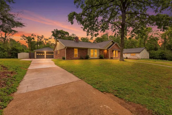 a front view of a house with yard and green space