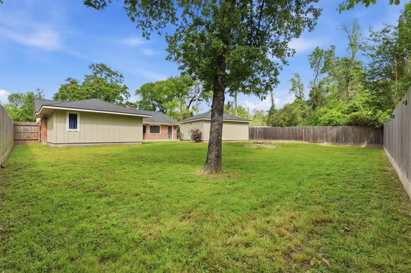 a view of a backyard with a small cabin and wooden fence