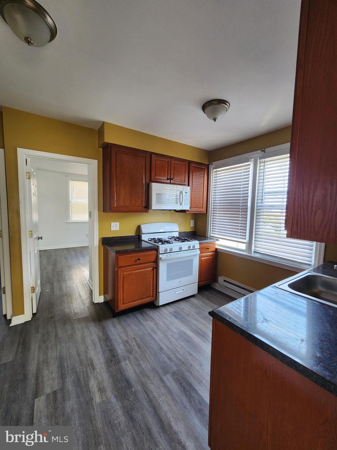 89 Sparks Street Philadelphia, PA 19120 - Photo 14 of 37 a kitchen with stainless steel appliances wooden floors and wooden cabinets