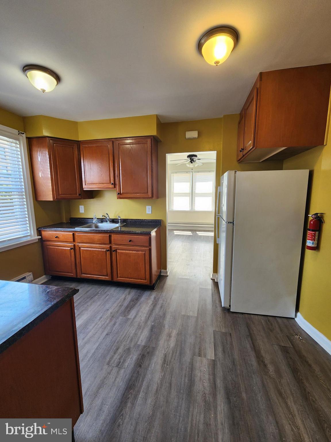 89 Sparks Street Philadelphia, PA 19120 - Photo 15 of 37 a kitchen with stainless steel appliances wooden cabinets and a wooden floor