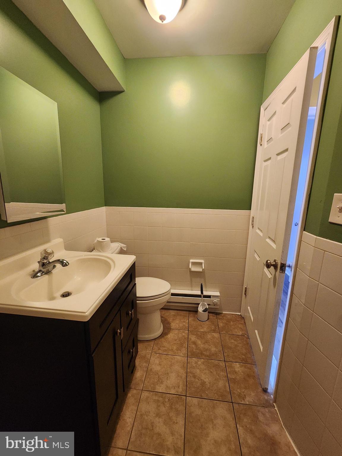89 Sparks Street Philadelphia, PA 19120 - Photo 18 of 37 a bathroom with a sink a toilet and a mirror
