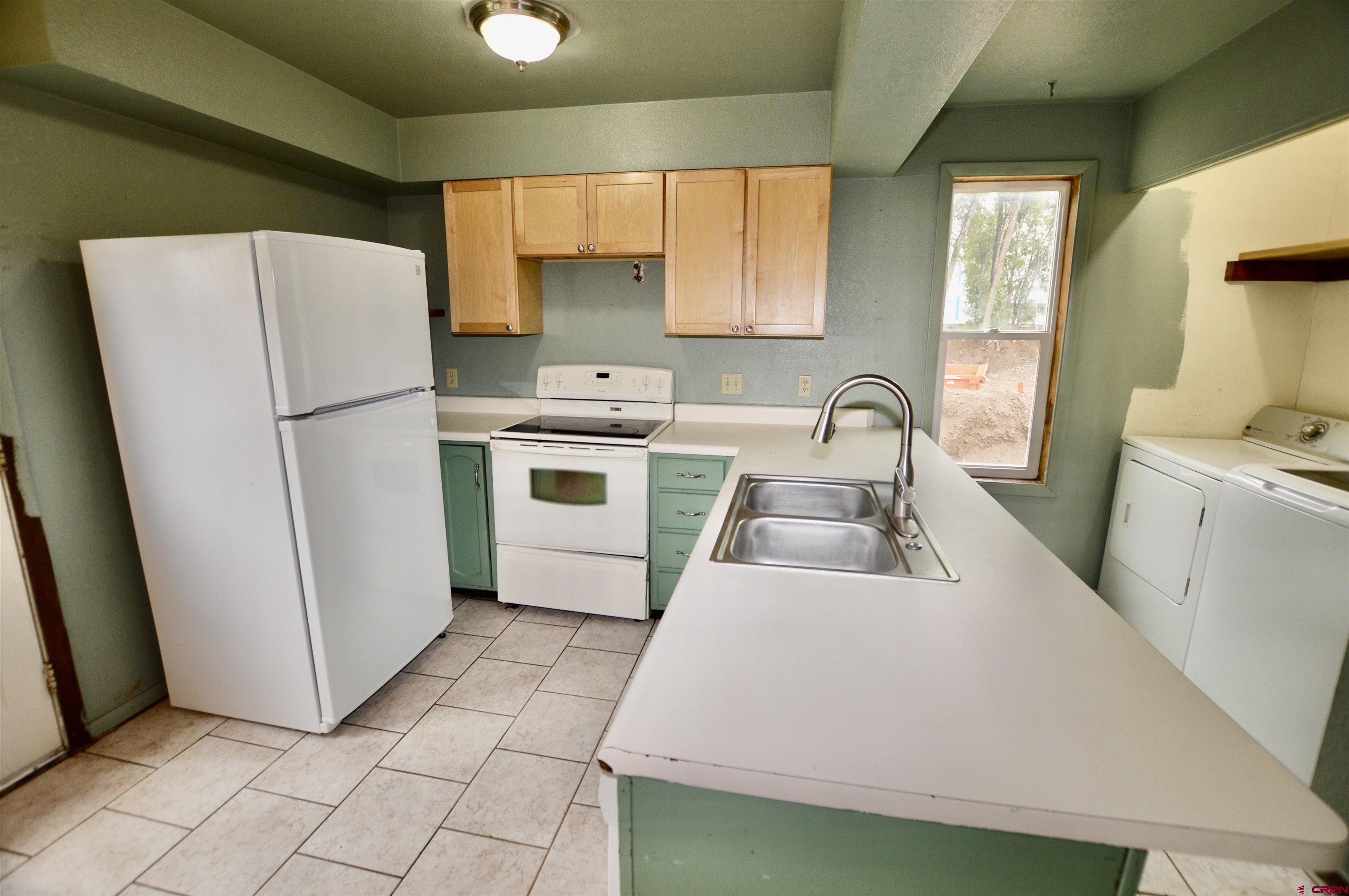 1005 West Denver Avenue, Unit G4 Gunnison, CO 81230 - Photo 5 of 21 a kitchen with a refrigerator sink stove and cabinets