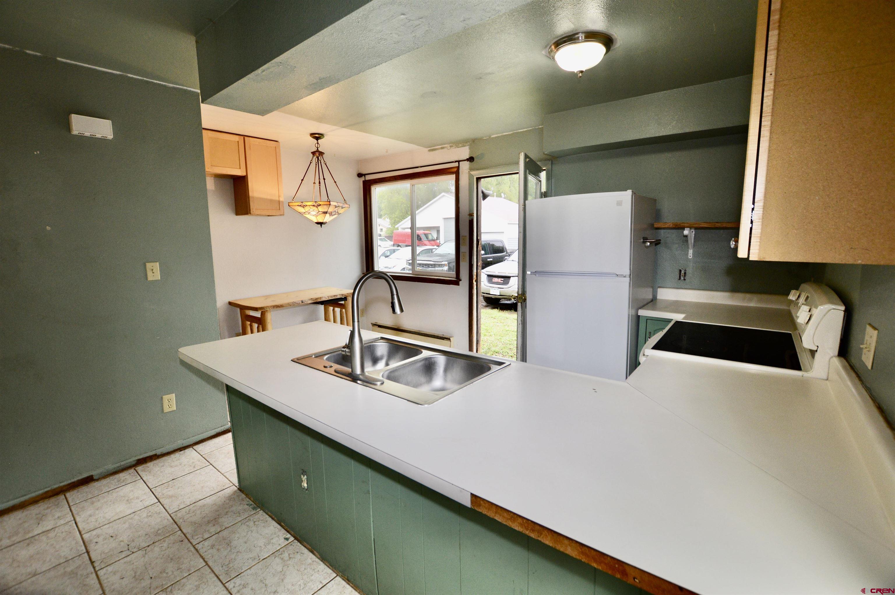 1005 West Denver Avenue, Unit G4 Gunnison, CO 81230 - Photo 7 of 21 a kitchen with stainless steel appliances a sink and a refrigerator