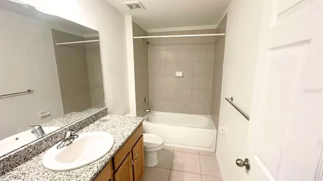 a bathroom with a granite countertop sink and a mirror a bathtub
