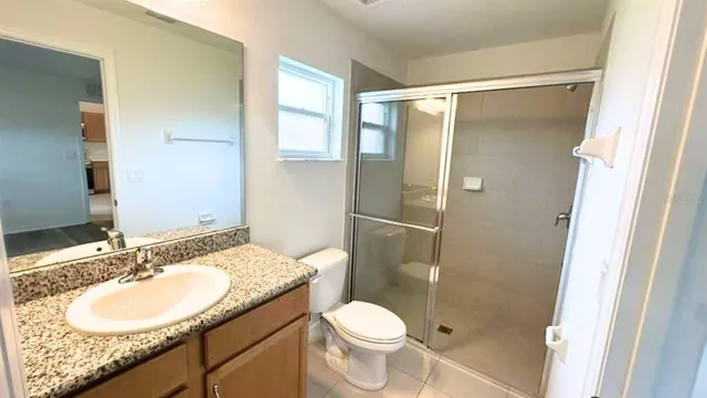 a bathroom with a granite countertop sink toilet and shower