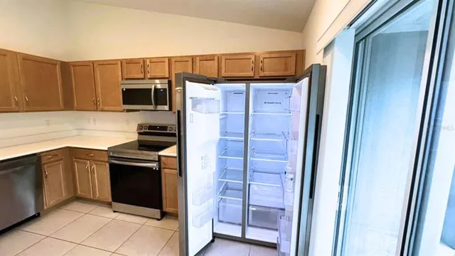 a kitchen with stainless steel appliances granite countertop a refrigerator and a sink