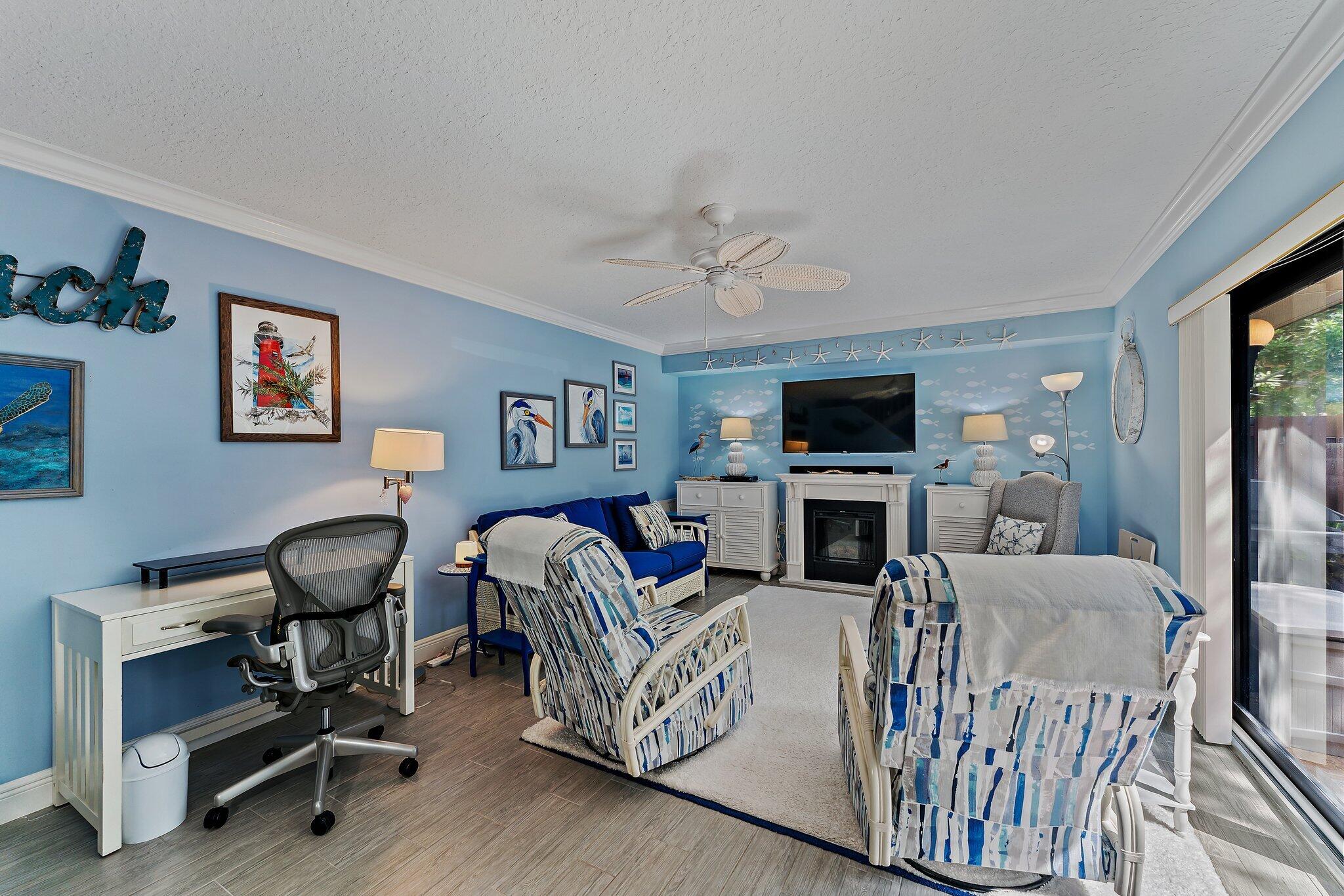 2403 24th Court Jupiter, FL 33477 - Photo 14 of 29 a living room with furniture a fireplace and a flat screen tv