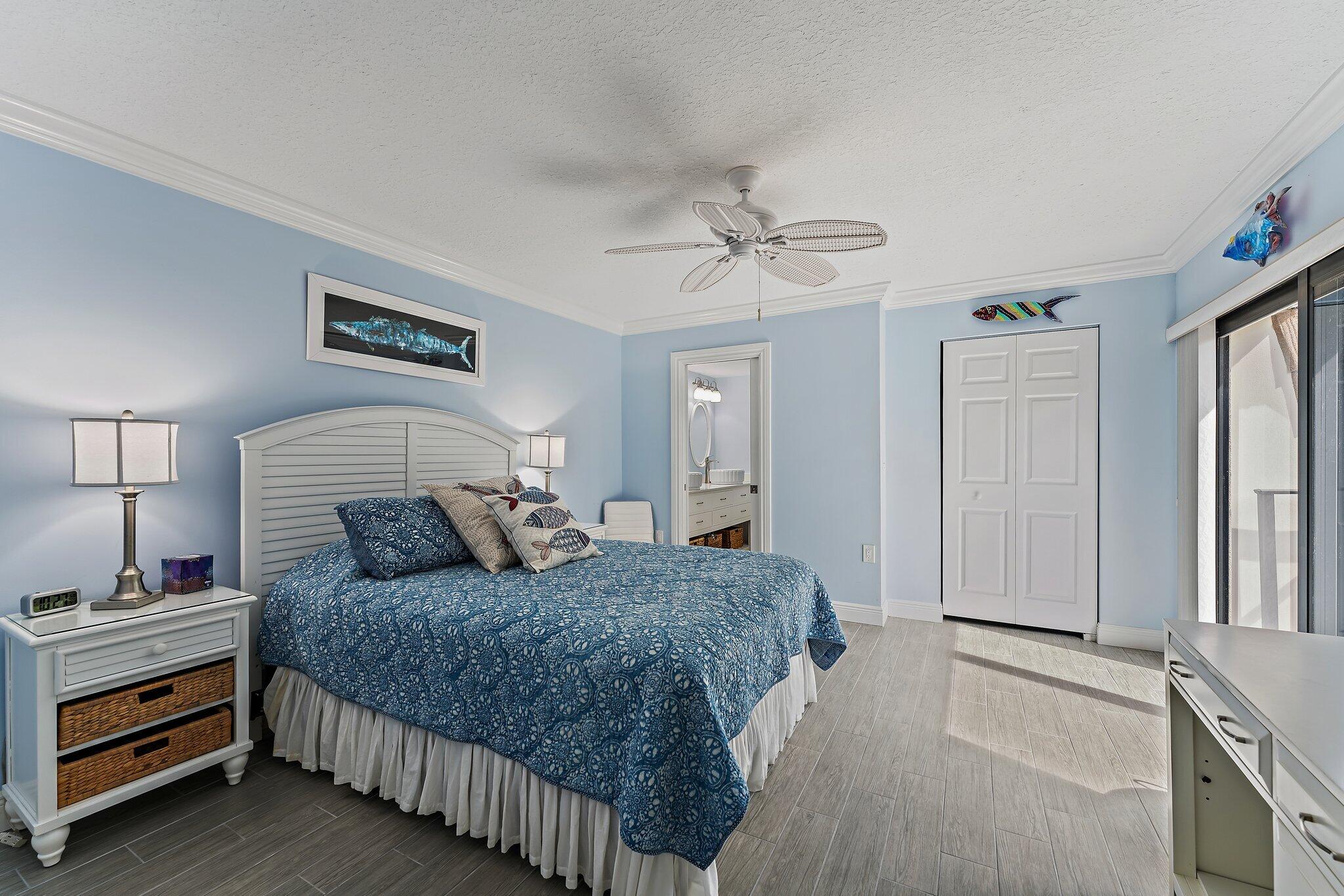2403 24th Court Jupiter, FL 33477 - Photo 18 of 29 a bedroom with a bed and a chandelier