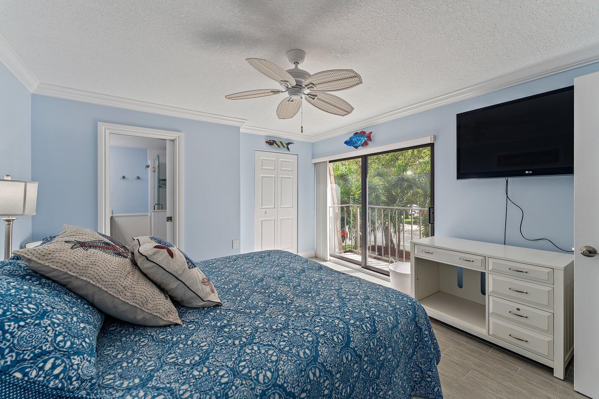 2403 24th Court Jupiter, FL 33477 - Photo 19 of 29 a bedroom with a bed and a flat screen tv