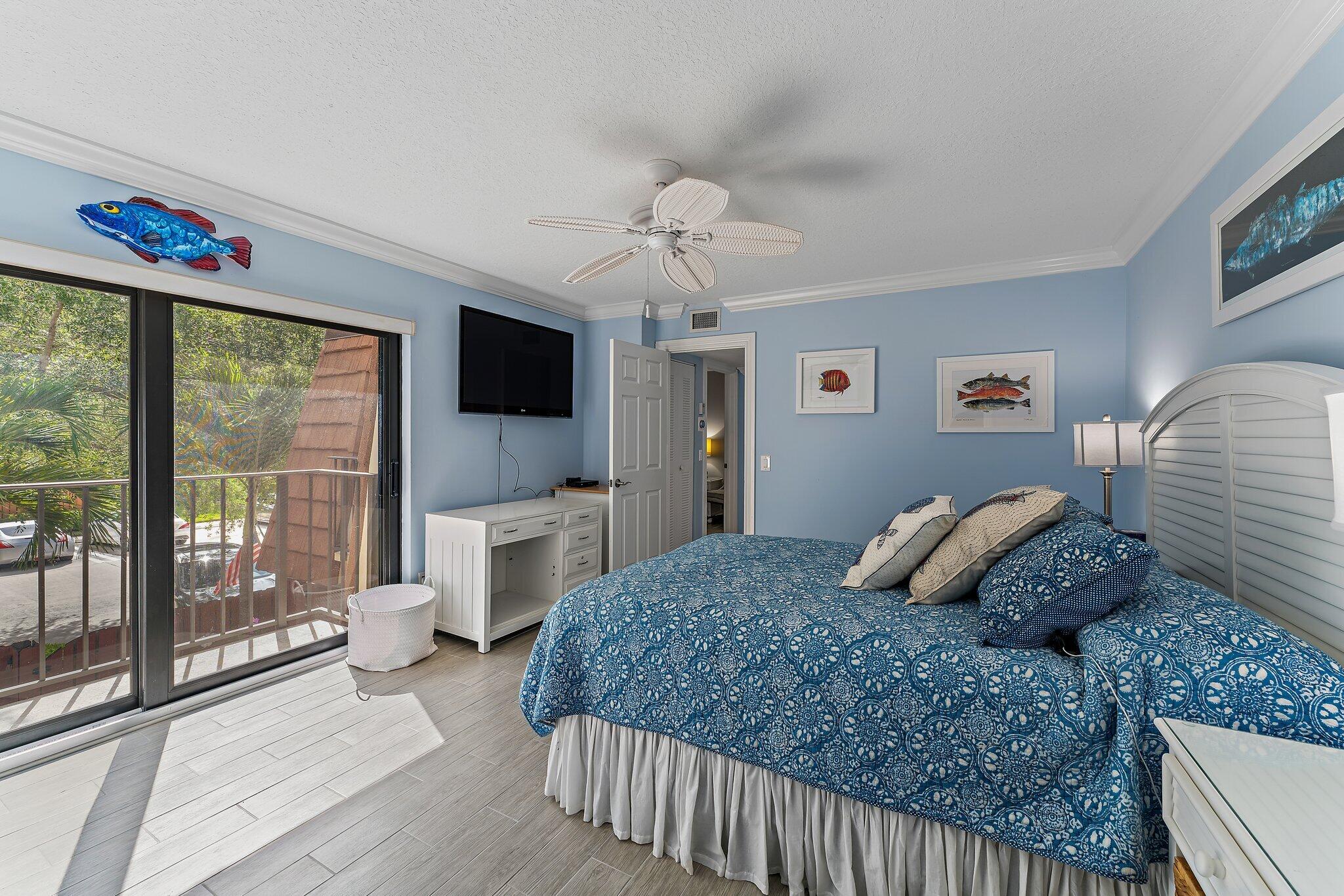 2403 24th Court Jupiter, FL 33477 - Photo 20 of 29 a bedroom with a large bed and a flat tv screen